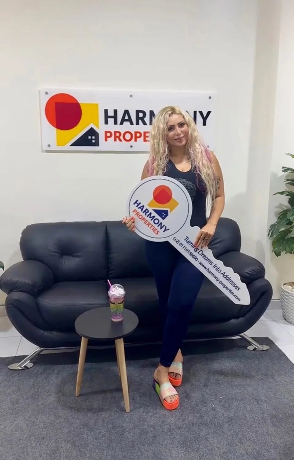 A happy Harmony Properties client holding the branded key